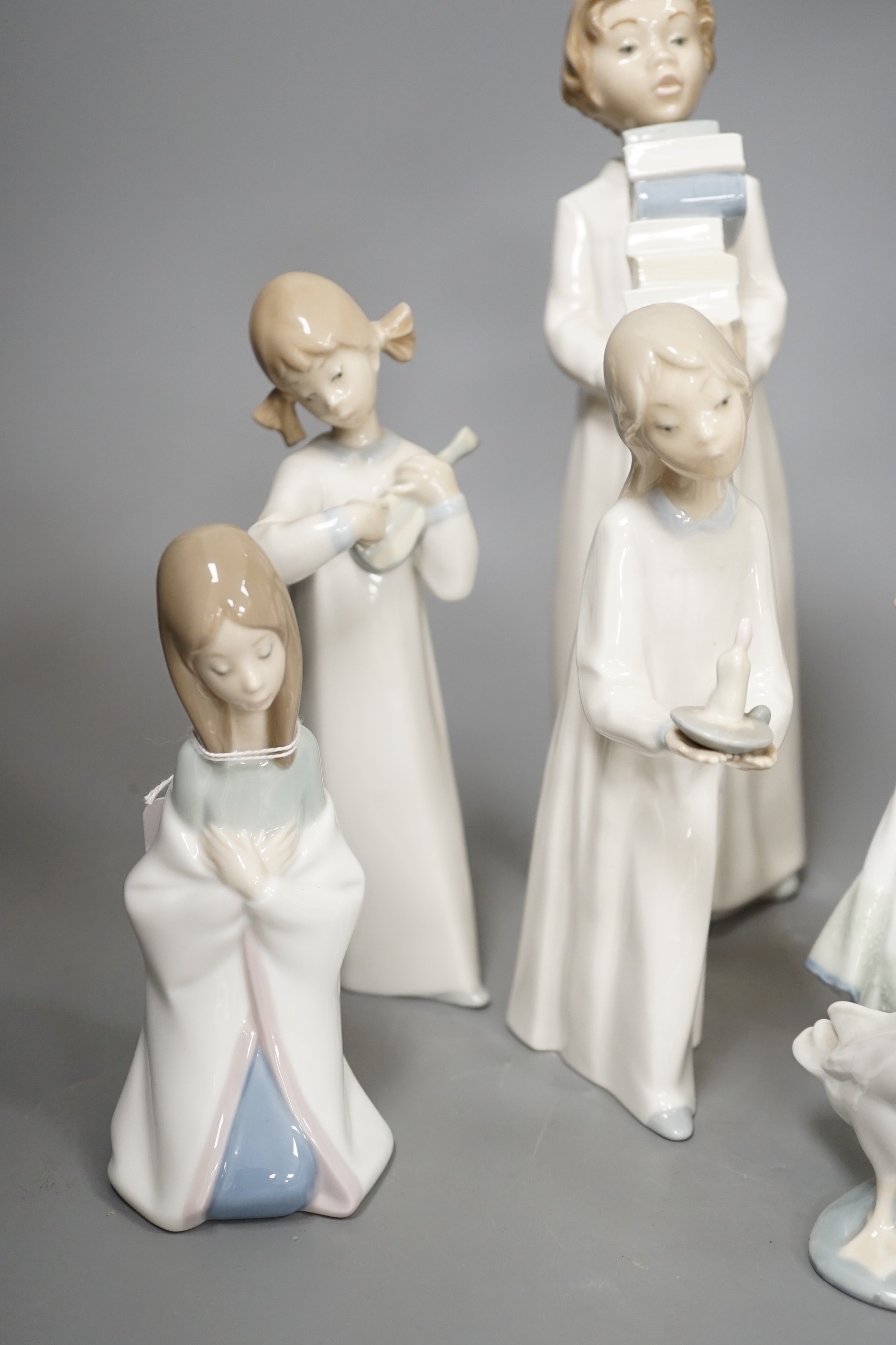 Seven Lladro figures together with two Nao figures. Tallest 29cm